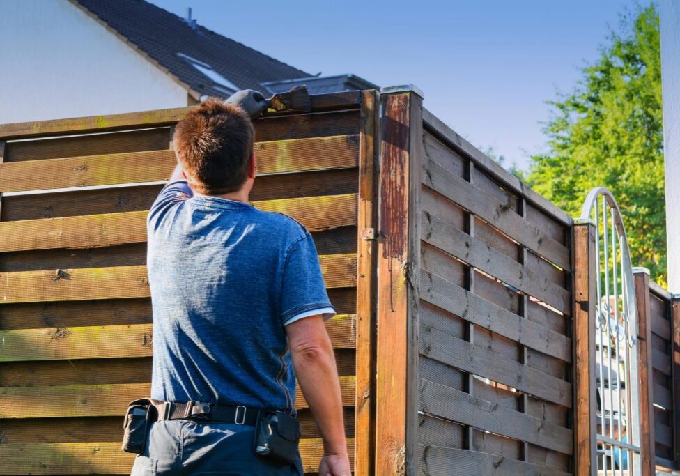 worker installing wood fence
